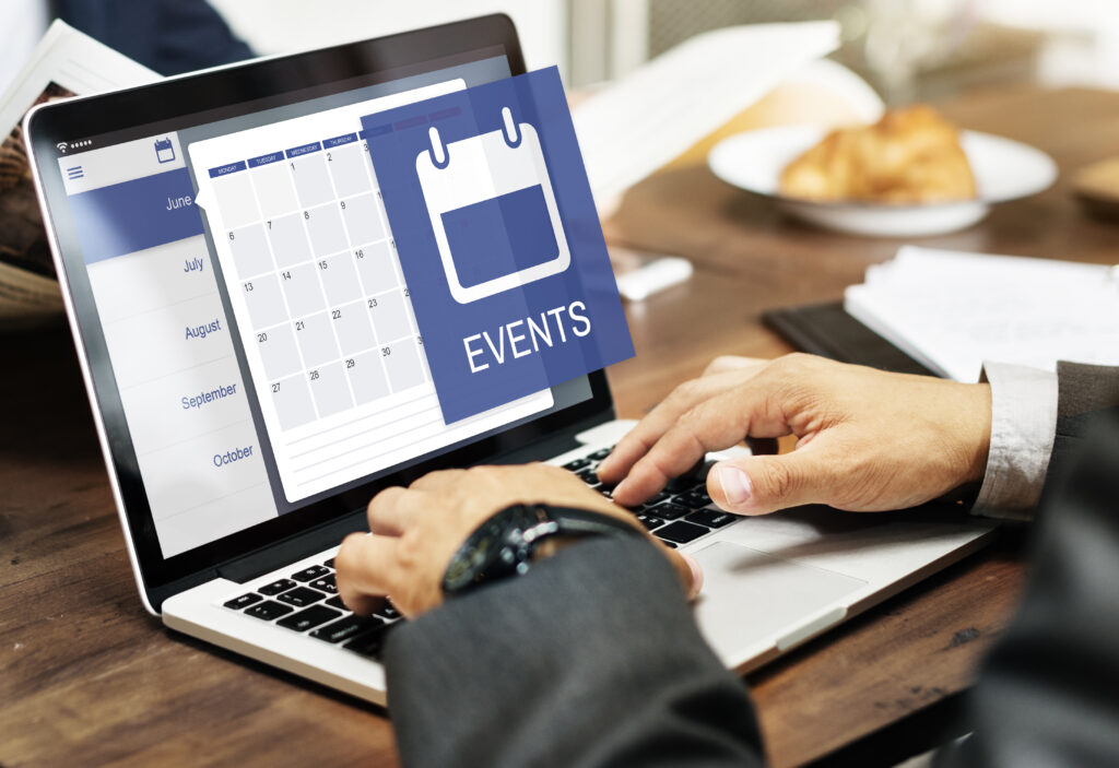 Close-up of hands typing on a laptop, displaying an online calendar with months and dates, and a prominent 'EVENTS' overlay with a calendar icon. This represents event management software and online appointment scheduling.